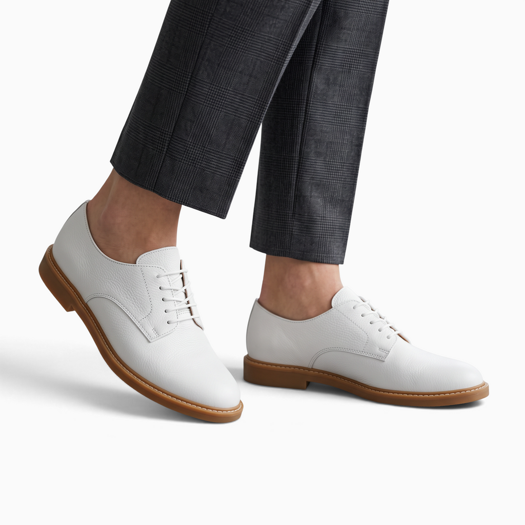 Mocassin Paris femme en cuir blanc à bout pointu et lacets, porté avec un pantalon habillé gris à carreaux