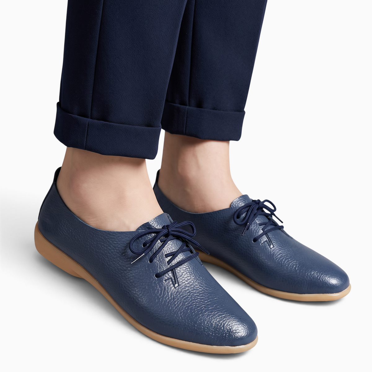 Mocassin Paris femme en cuir bleu à bout pointu et lacets, porté avec un pantalon bleu marine