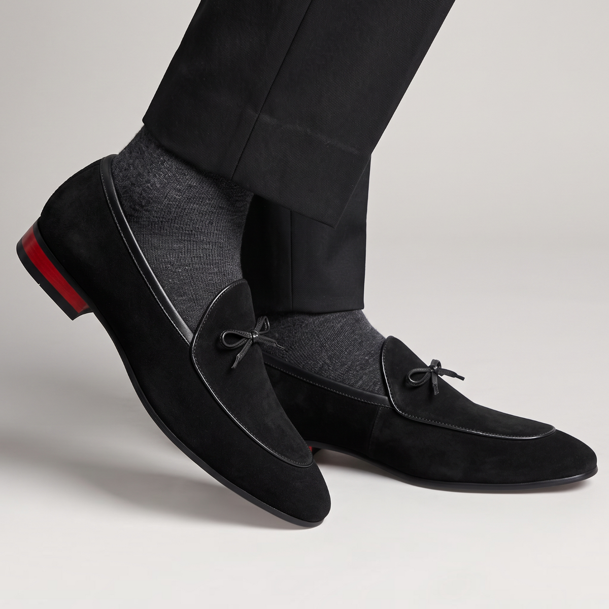 Mocassin Paris homme en daim noir avec nœud décoratif et talon à détail rouge pour une tenue de cérémonie élégante