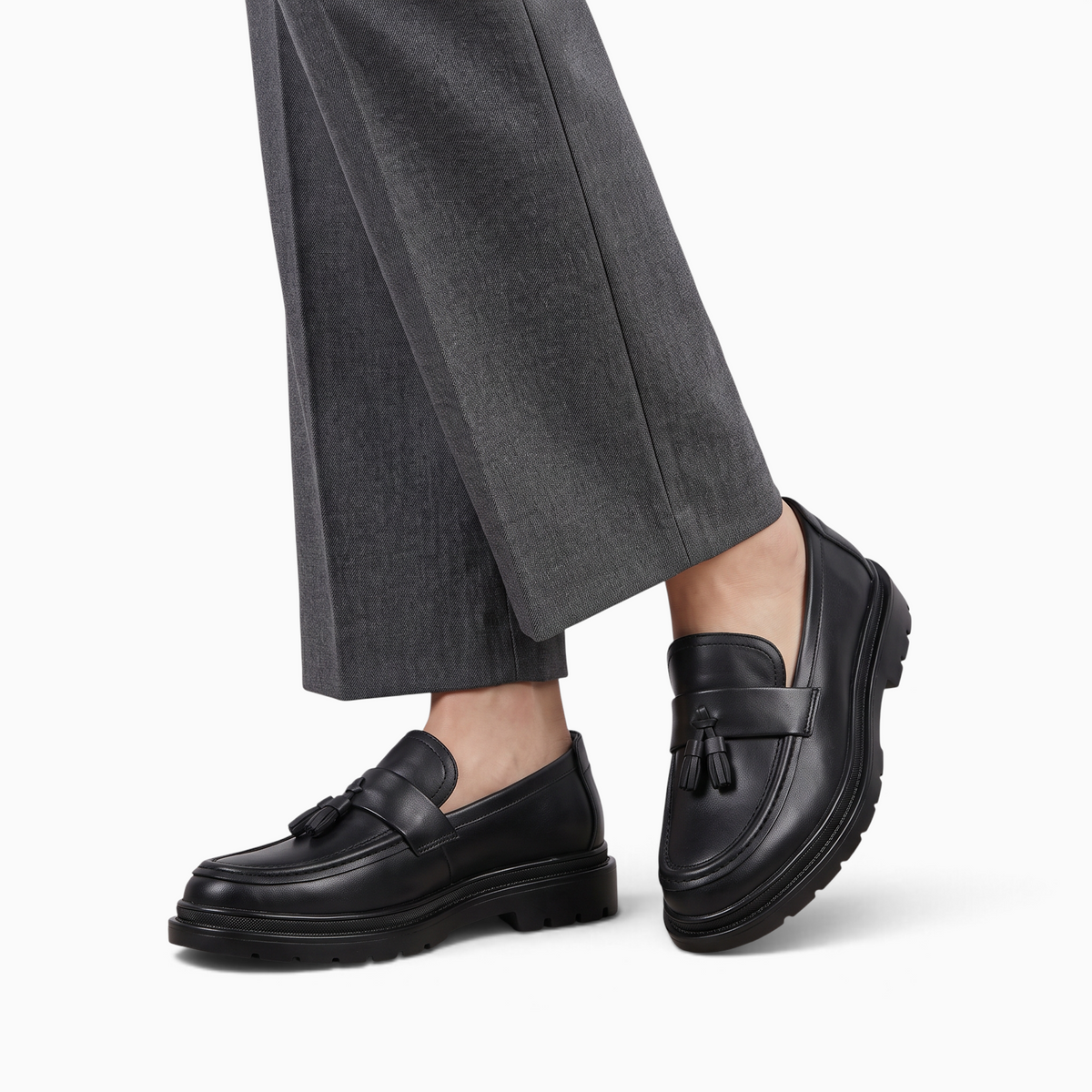 Mocassin Paris homme noir mat à plateforme et glands décoratifs porté avec un pantalon gris