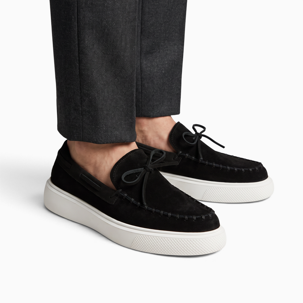 Mocassin Paris homme en daim noir avec semelle épaisse blanche et détails de surpiqûres, porté avec un pantalon gris