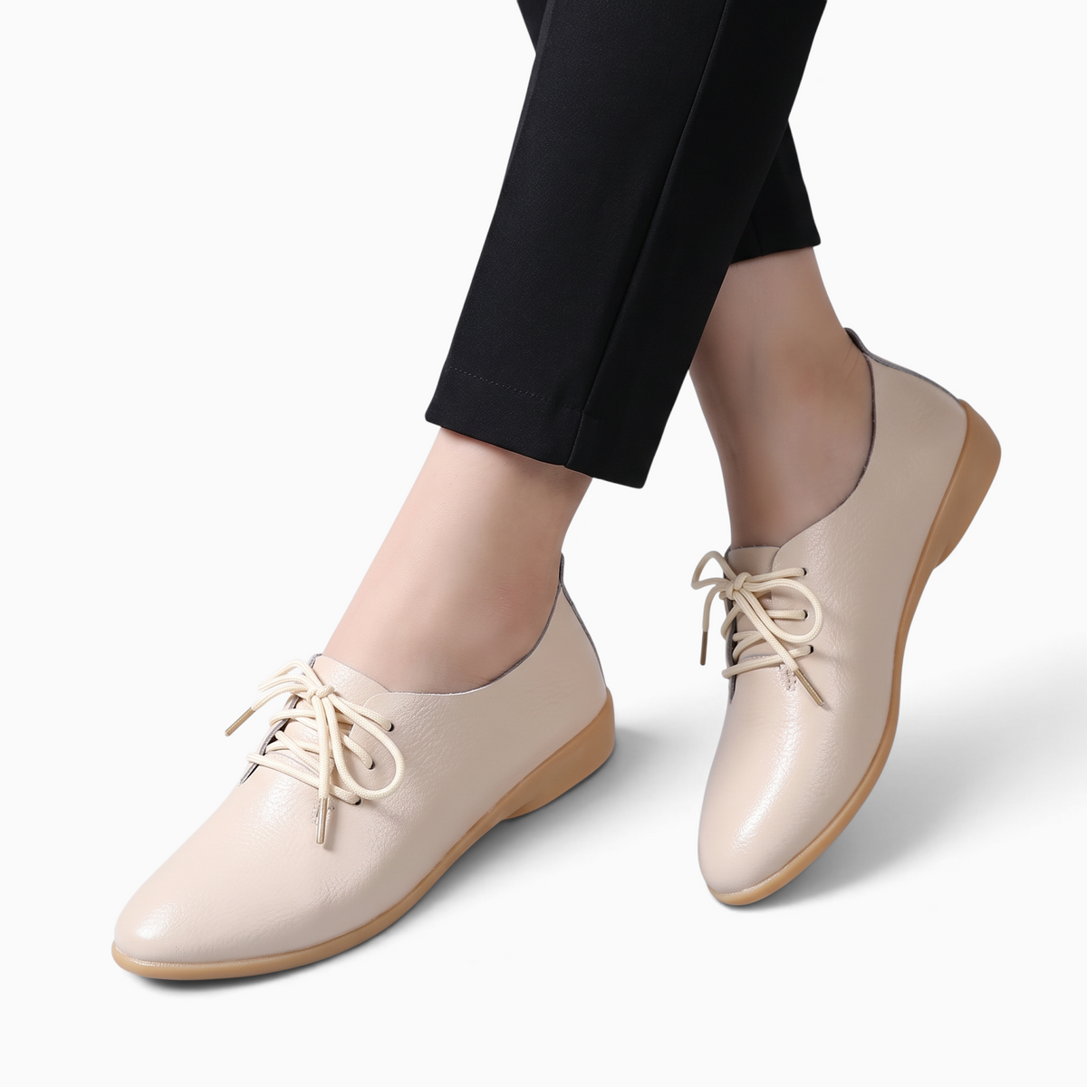 Mocassin Paris femme en cuir beige à bout pointu avec lacets assortis portés avec un pantalon noir